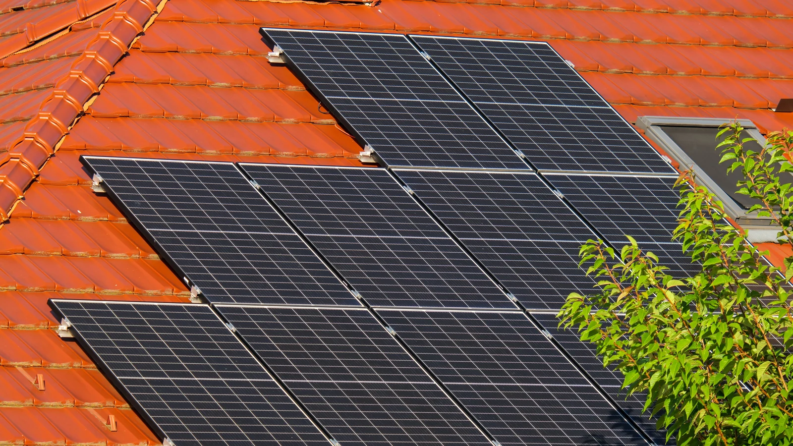Maison solaire en contexte européen Maison européenne avec panneaux photovoltaïques sur une toiture en tuiles rouges